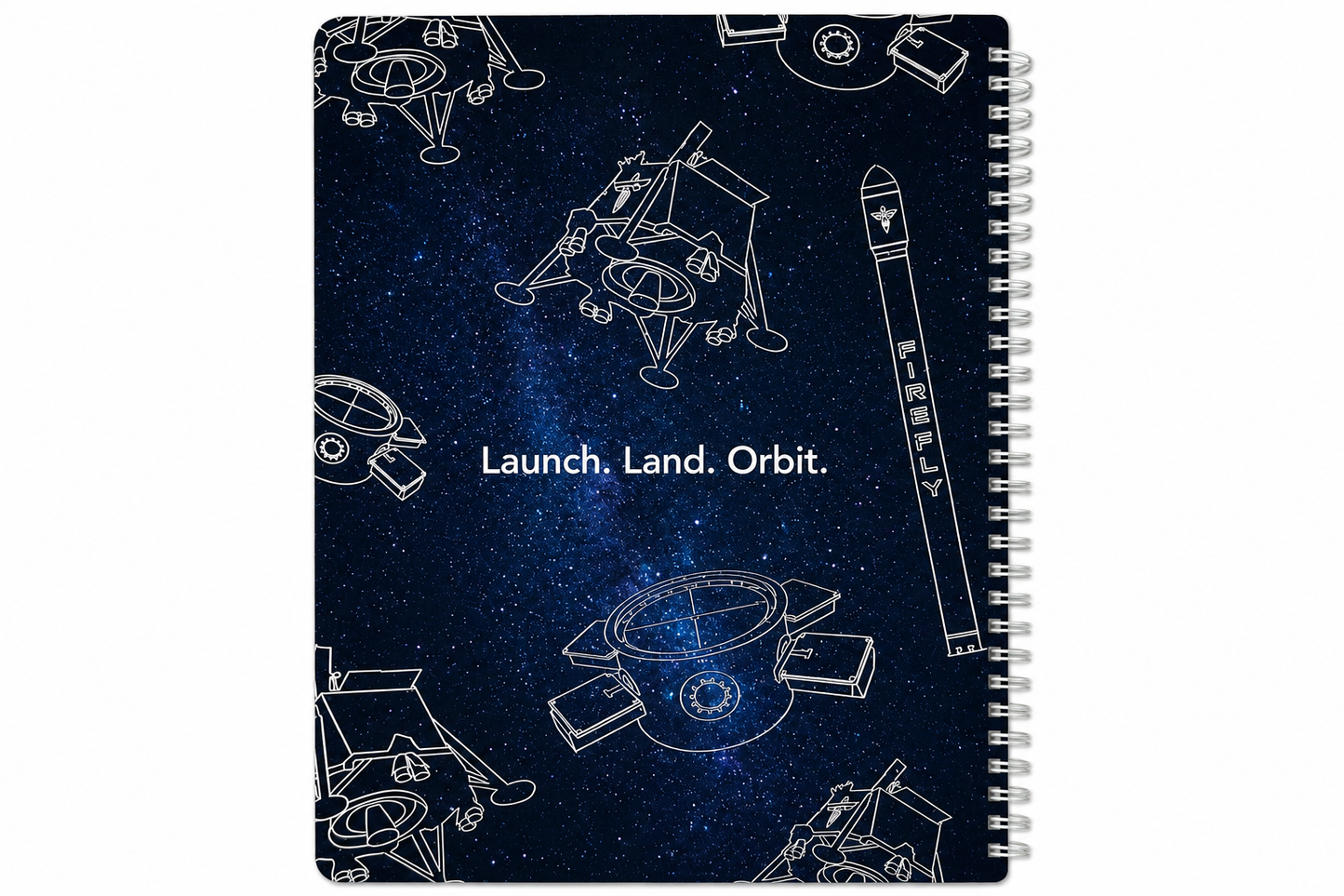 A spiral-bound notebook with a dark blue starry space cover design, featuring white line drawings of rockets, satellites, and the text 'Launch. Land.