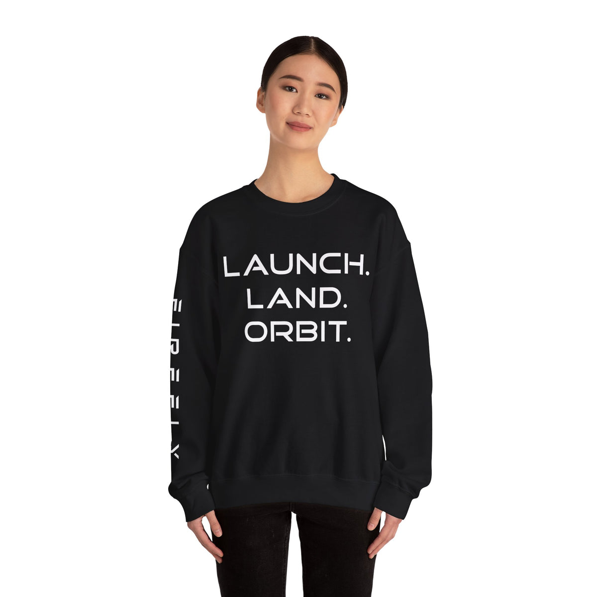 A woman modeling a black crewneck sweatshirt with bold white text reading 'LAUNCH. LAND.
