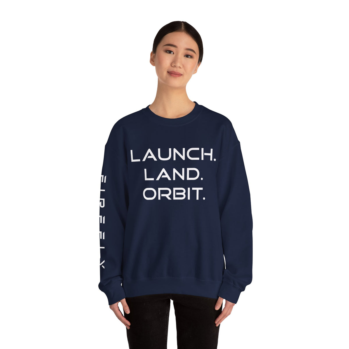A woman modeling a navy blue crewneck sweatshirt with white text reading 'LAUNCH. LAND.