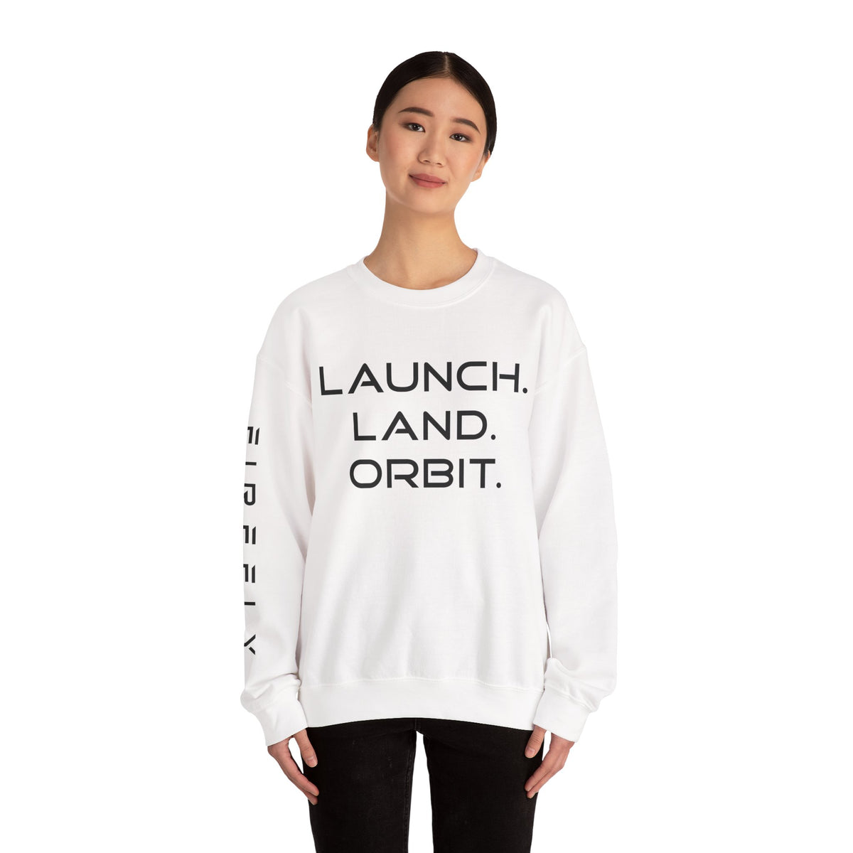 A woman modeling a white crewneck sweatshirt with black text reading 'LAUNCH. LAND.